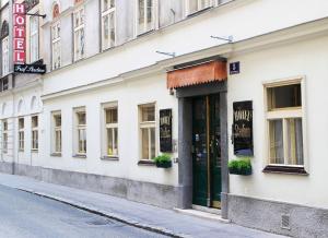 a white building with a green door on a street at Hotel Graf Stadion in Vienna