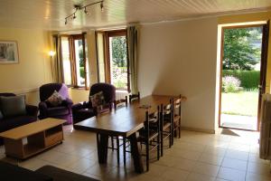 sala de estar con mesa de madera y sillas en Gîte 295 Montagnes du Jura avec Spa et Sauna classé 3 étoiles en Foncine-le-Haut