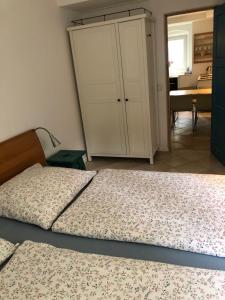 ベルリンにあるLilienthalschlösschenのベッドルーム1室(ベッド2台付)、キャビネット、キッチンが備わります。
