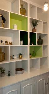 a room with white shelves with potted plants on them at ver(t) chez nous in Périgueux