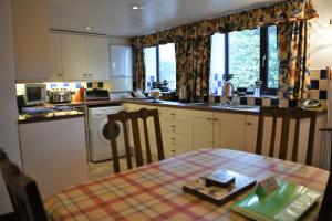 a kitchen with a table with a book on it at Laburnum Cottage Broadway in Broadway