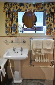 a bathroom with a sink and a mirror at Laburnum Cottage Broadway in Broadway