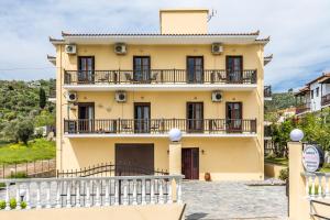 a large yellow house with a balcony at White Lily in Skopelos Town