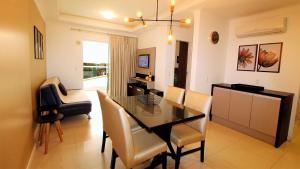 comedor y sala de estar con mesa y sillas en 1044 - Apartamento de 01 dormitório em Bombinhas - Residencial Egídio Pinheiro 101 B, en Bombinhas