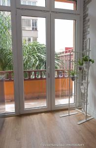ein leeres Zimmer mit Glasschiebetüren und Pflanzen in der Unterkunft Flatguest Living House in Las Palmas de Gran Canaria
