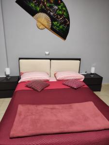 a bed with a red blanket and pillows on it at Tufaro B&B in Macerata Campania
