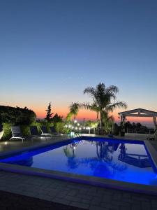 a large swimming pool with a sunset in the background at Casa Vacanze Belvedere in Partinico