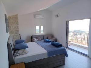 a bedroom with a bed with blue pillows on it at Olive Stone House in Makarska +71 photos