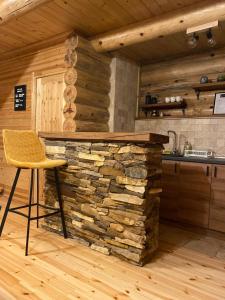 cocina con pared de piedra y silla en una habitación en Brvnare Park Borova en Zlatibor