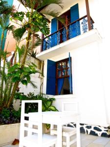 Casa blanca con ventanas azules y balcón. en Pousada Estrela do Mar, en Salvador