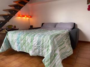 Schlafzimmer mit einem Bett mit einer grünen und weißen Bettdecke in der Unterkunft La casa sul comó in Neapel