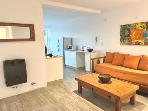 a living room with a couch and a table at Gran departamento a metros de la laguna para parejas in Chascomús