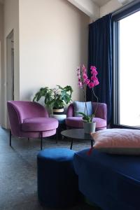 a living room with purple chairs and a table at Picobello Lago in Mandello del Lario