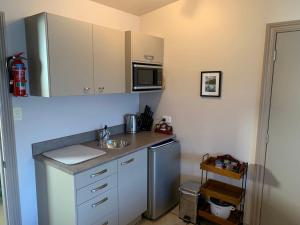 a small kitchen with a sink and a microwave at King's View Lodge in Whangaroa
