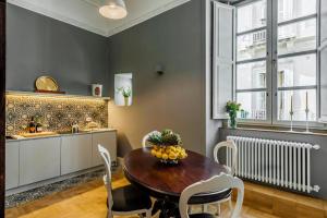 a dining room with a table and chairs and a kitchen at Dimora delle Maestranze (Ortigia) in Siracusa +19 photos
