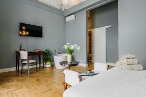 a bedroom with a bed and a table and chairs at Dimora delle Maestranze (Ortigia) in Siracusa