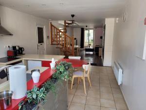 a kitchen and dining room with a red counter top at Chez le Paul in Viéville