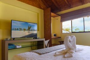 Un dormitorio con una cama con toallas blancas. en Wallac Bungalows Canoas de Punta Sal, en Canoas de Punta Sal