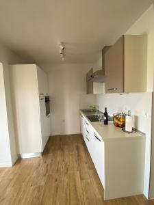 a kitchen with white cabinets and a wooden floor at Country House Peace in Drinovci