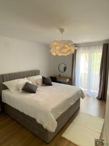 DrinovciにあるCountry House Peaceのベッドルーム(大きな白いベッド1台、シャンデリア付)