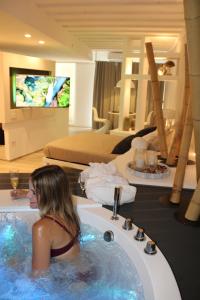 una mujer sentada en una bañera en una habitación de hotel en Suite Home3 beb, en Bisceglie
