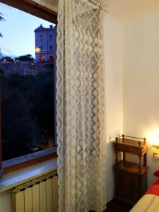 a window curtain in a bedroom with a view of a building at Il Bijoux in Perugia