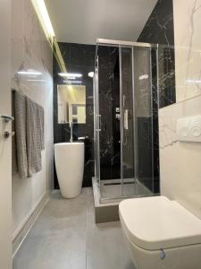 e bagno con doccia, servizi igienici e lavandino. di Luxury apartment, private parking,7 a Craiova