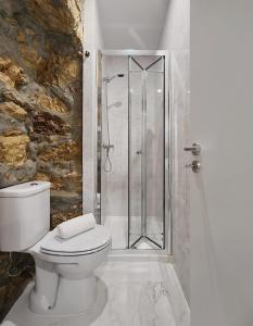 a bathroom with a toilet and a glass shower at COIMBRA CITY CHARM in Coimbra