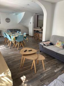 een woonkamer met een bank en een tafel en stoelen bij Maison 8-10 pers avec piscine aux portes de St Aygulf in Fréjus