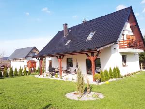 Biały dom z czarnym dachem w obiekcie Pokoje Przy Polanie w Stroniu Śląskim