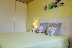 a bedroom with a large white bed with two pillows at Gîte 1805 Montagnes du Jura avec Spa et Sauna classé 2 étoiles in Foncine-le-Haut
