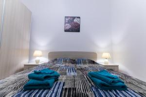- 2 serviettes bleues assises au-dessus d'un lit dans l'établissement Seaside Cosy Maisonette @ Marsaskala - 2 mins walk from sea, à Marsaskala