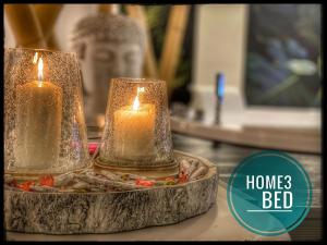 two candles on a table with a statue in the background at Suite Home3 beb in Bisceglie