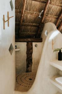 a bathroom with a bath tub and a wooden ceiling at Mahayana Tulum Beach Homes in Tulum