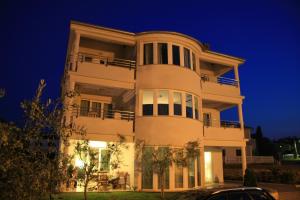 a large white building at night at Apartments Kovacic in Malinska