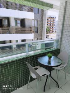 a balcony with a table and two chairs at Israel Flat Tambaú in João Pessoa