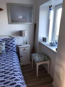 um quarto com uma cama, uma mesa e uma cadeira em The Thin Seagull 4 Beacon Terrace Ferryden em Ferryden