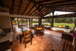 a large patio with tables and chairs and windows at Hospedaje Villa Eucalyptus in Nobsa