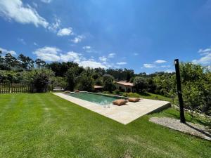 a swimming pool in the middle of a yard at Casa de Vilar de Rei, férias em família com piscina in Ponte de Lima
