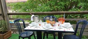 - une table blanche avec des chaises et des boissons dans l'établissement Les Terrasses du Lac piscine M65, à Aureilhan