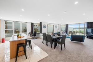 a dining room and living room with a table and chairs at Lakeside Apartment Waimahana 1 in Taupo