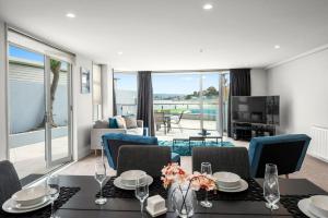 uma sala de estar com uma mesa de jantar e uma sala de estar em Lakeside Apartment Waimahana 1 em Taupo