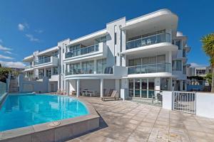 an image of a large white building with a swimming pool at Lakeside Apartment Waimahana 1 in Taupo