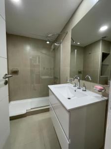 un baño con lavabo y ducha en Acqua Apartments Bariloche, en San Carlos de Bariloche 122 fotos más