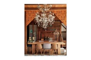 a dining room with a table and a chandelier at Bleu Verde, The Self Healing Hotel & Retreat in Gili Trawangan