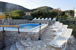 a group of white chairs sitting around a pool at Two-Bedroom House with Shared Pool in heart of Seget in Trogir