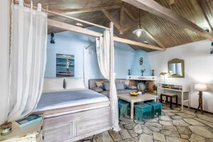 1 dormitorio con cama con dosel y escritorio en Yianna Cottage Studios, en Skopelos Town