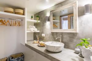 baño con lavabo grande y espejo en Yianna Cottage Studios, en Skopelos Town
