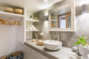 une salle de bain avec un grand lavabo et un miroir dans l'établissement Yianna Cottage Studios, à Skopelos
