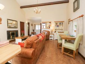 a living room with a couch and a table at Topiary Cottage in Staveley